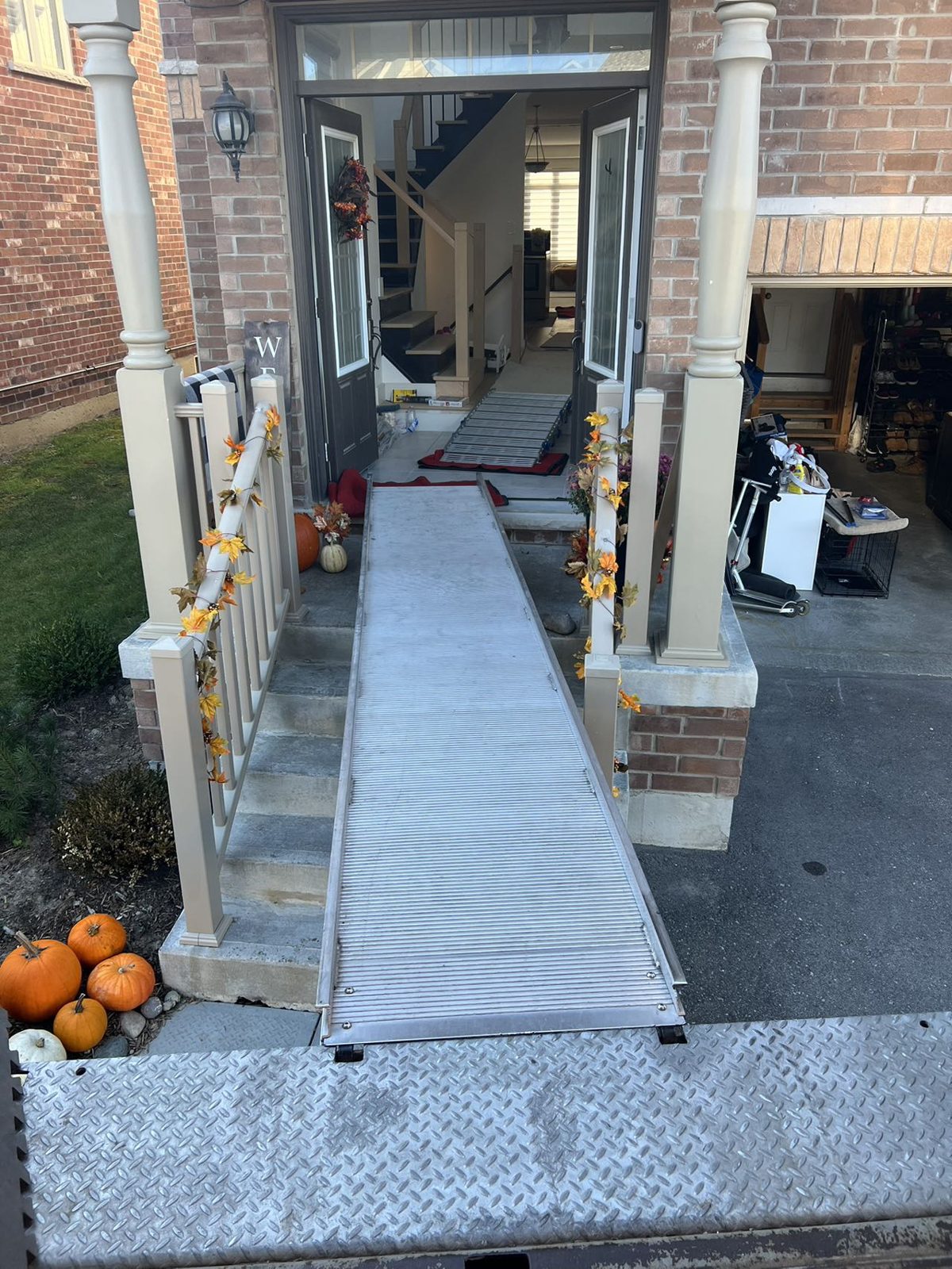 Moving truck ramp bridged over the front steps directly to the open front door of a house